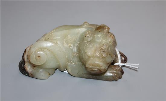 A Chinese pale grey and black jade recumbent lion-dog 9.5cm long